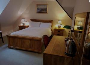 1 dormitorio con 1 cama y escritorio con 2 lámparas en AbingPlough House en Abingdon