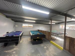 a garage with two pool tables and a ping pong table at Echo Beach Tourist Park in Lakes Entrance