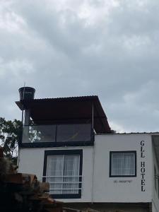 una casa bianca con tetto nero e due finestre di GLL HOTEL a El Cocuy