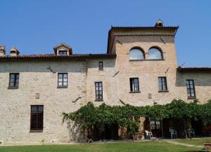 un grande edificio in mattoni con finestre e un albero di Ferienhaus für 25 Personen und 2 Kinder in Citta di Castello, Trasimenischer See a Città di Castello