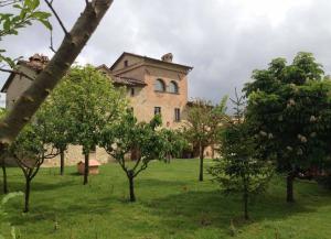 un grand bâtiment avec des arbres devant lui dans l'établissement Ferienhaus für 25 Personen und 2 Kinder in Citta di Castello, Trasimenischer See, à Città di Castello