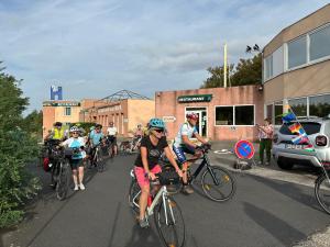 a group of people riding bikes down a street at HOTEL De La Tour Saint Etienne SUD in Saint Etienne