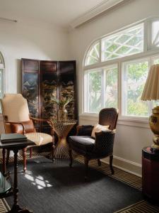 a living room with chairs and a window at The Puakenikeni Suite at the Historic Wailuku Inn in Wailuku