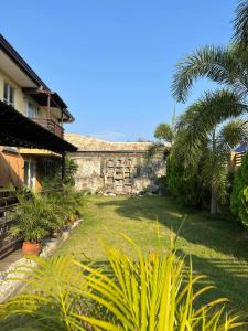 a garden with palm trees and a stone building at Softwind Villa Hotel and Resort in Santa Catalina