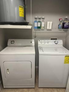- une cuisine équipée de 2 appareils électroménagers blancs dans un réfrigérateur dans l'établissement Devine Livings at Hermann Park, à Houston