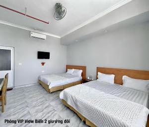 pokój hotelowy z dwoma łóżkami i telewizorem w obiekcie Khách sạn Hà Nội 2 Mặt Biển Sầm Sơn w mieście Sam Son