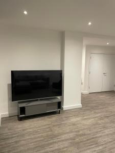 a living room with a large flat screen tv at Luxurious 2 Bedroom Apartment in Barking