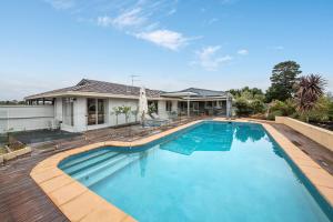 a swimming pool in front of a house at High Vista in Mount Eliza with Pool in Mount Eliza