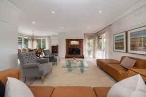 a living room with a couch and a table at High Vista in Mount Eliza with Pool in Mount Eliza