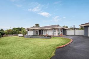 a house with a large lawn in front of it at High Vista in Mount Eliza with Pool in Mount Eliza