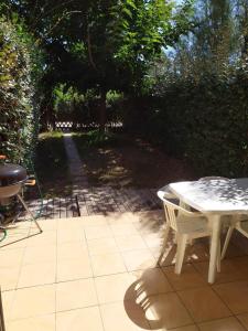 ein Tisch und Stühle auf einer Terrasse in der Unterkunft Villa les pieds dans l'eau in Borgo + 2 Fotos