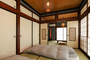 1 dormitorio con 2 camas en una habitación con ventanas en 貸切民泊宿 だんねだんね Private guest house Danne-Danne en Ōno
