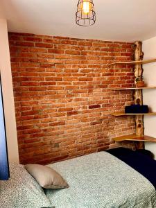 a bedroom with a brick wall and a bed at Casa Camara in Mexico City