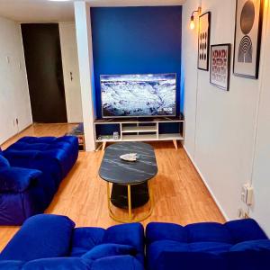 a living room with blue couches and a table at Casa Camara in Mexico City