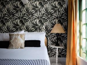 a bedroom with a bed with a black and white wallpaper at The Lehua Suite at the Historic Wailuku Inn Maui in Wailuku