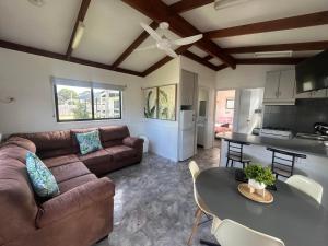 a living room with a couch and a table at Echo Beach Tourist Park in Lakes Entrance