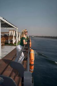 a woman sitting on a boat in the water at NILE CRUISE LUXOR & AsWAN نايل كروز الاقصر و اسوان in Aswan