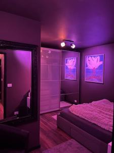 - une chambre violette avec un lit et un miroir dans l'établissement Luxurious apartment in Reykjavík, à Reykjavik