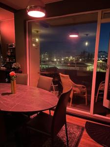 d'une salle à manger avec une table, des chaises et une fenêtre. dans l'établissement Luxurious apartment in Reykjavík, à Reykjavik