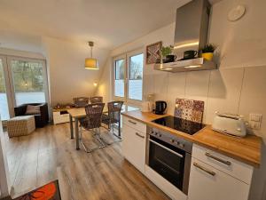 a kitchen and living room with a table and chairs at Wellenbreker-H in Hohwacht