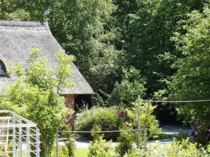 a garden with a thatch roof and some plants at Wellenbreker-H in Hohwacht