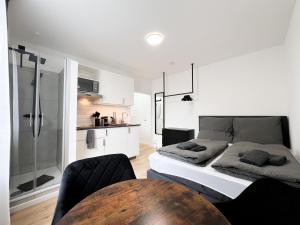 a bedroom with a bed and a table and a kitchen at Cityapartments Düsseldorf - Stadtmitte in Düsseldorf