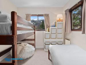 a bedroom with two bunk beds and a lamp at Chamonix in Thredbo