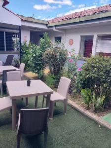 une terrasse avec une table et des chaises devant une maison dans l'établissement Hostal casa 25, à Santa Ana