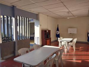 une chambre avec des tables et des chaises dans un bâtiment dans l'établissement Hostal casa 25, à Santa Ana