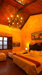 a bedroom with two beds and a chandelier at Casa Familiar San Sebastian in Antigua Guatemala