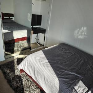 1 dormitorio con cama y espejo. en Bedroom & Private Bathroom in Modern Inner Brisbane Apartment, en Brisbane