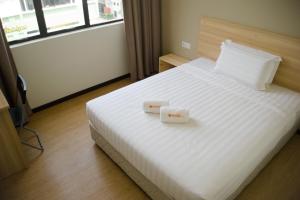 Postel nebo postele na pokoji v ubytování 1 Orange Hotel Sungai Buloh