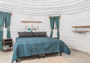 1 dormitorio con 1 cama con edredón azul en Eco Domos los Jaguares en Puerto Morelos