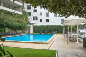 a swimming pool with a table and an umbrella at Harbourside #49 in Sydney