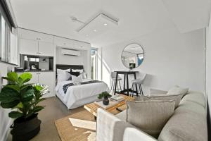 a bedroom with a bed and a living room with a couch at Modern Potts Point Studio in Sydney