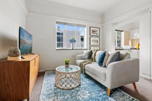 een woonkamer met een bank en een salontafel bij Lovely Apartment with Spectacular Views in Sydney