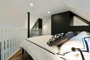 a bedroom with a black and white bed with pillows at New York style Loft in Sydney