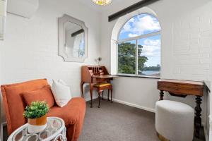 een woonkamer met een oranje bank en een raam bij Lovely Apartment with Spectacular Views in Sydney