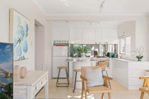 a kitchen with white cabinets and a table and chairs at Harbourside #31 in Sydney