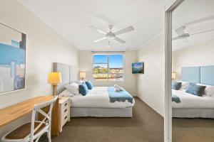 a bedroom with two beds and a desk and a window at Harbourside #31 in Sydney