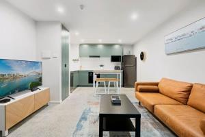 a living room with a couch and a kitchen at Cosy Camperdown in Sydney