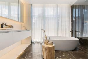 a bathroom with a white tub and a sink at Terrace Boutique in the Heart of The Rocks in Sydney +12 photos