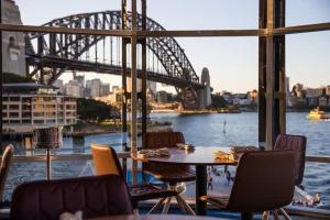 a table and chairs with a view of a bridge at Terrace Boutique in the Heart of The Rocks in Sydney