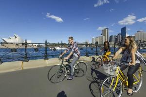 un gruppo di persone che cavalca biciclette su un ponte di Terrace Boutique in the Heart of The Rocks a Sydney