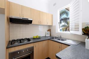 a kitchen with a stove and a sink and a window at Absolute Seafront Bronte in Sydney