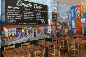 a restaurant with wooden tables and chairs and a sign at Absolute Seafront Bronte in Sydney