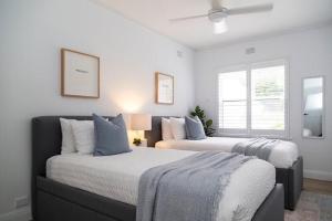 Duas camas num quarto com paredes brancas em Woollahra Wonder em Sydney