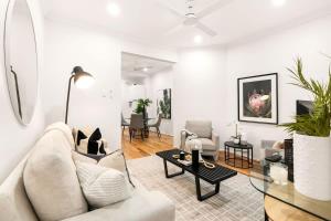 sala de estar con sofá blanco y mesa en Comfy Darlinghurst Retreat, en Sídney