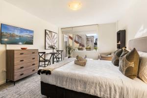 a bedroom with a large bed and a living room at Sunny Spot Potts Point in Sydney