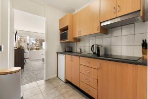 a kitchen with wooden cabinets and black counter tops at Sunny Spot Potts Point in Sydney